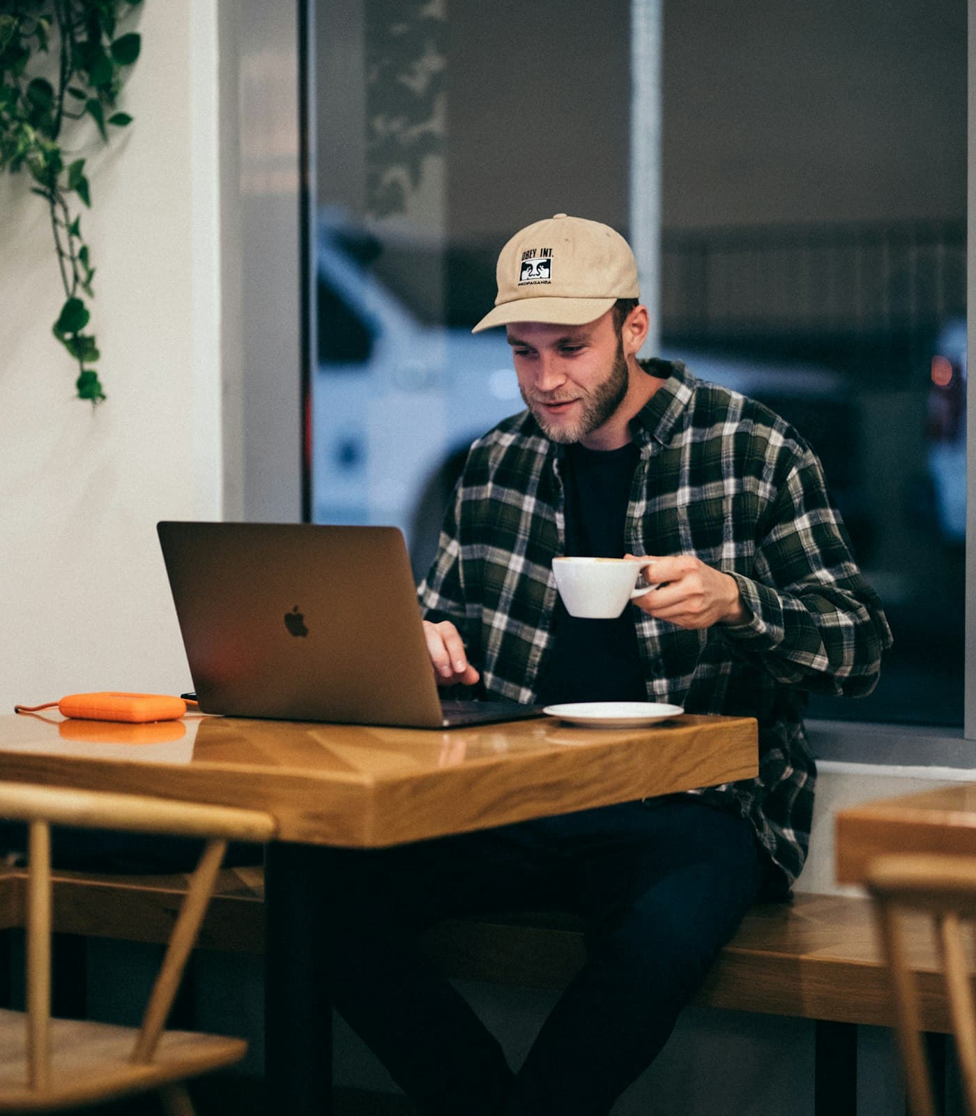 A builder working on a laptop with a cup of coffee at a cafe counter